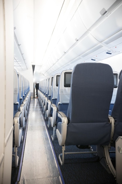 Een economy class cabine van het vliegtuig een ruim gangpad