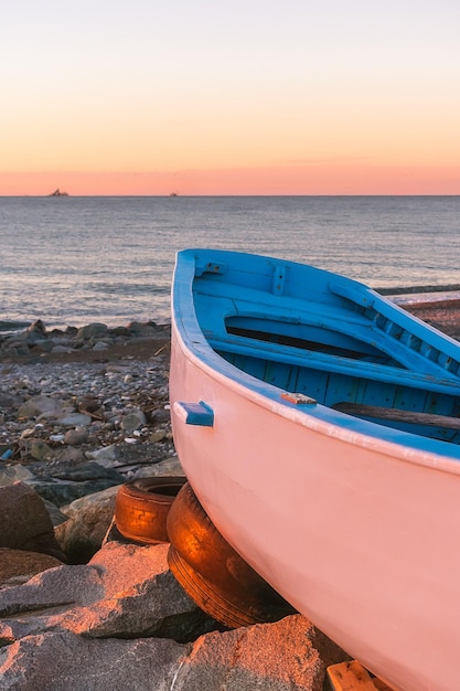 Foto een eenvoudige geschilderde houten boot aan de kust tijdens zonsondergang boot aan de oever van de zwarte zee