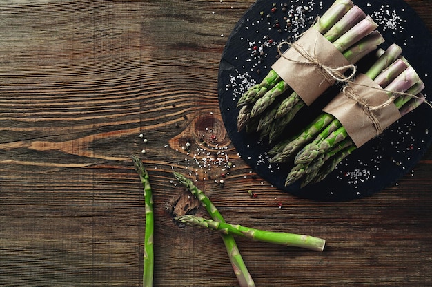 Een eetbare rauwe stengels van asperges op een houten ondergrond