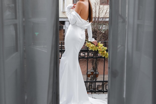 Een elegant meisje in een prachtige witte jurk met bloemen in haar handen Close Up foto geïsoleerd