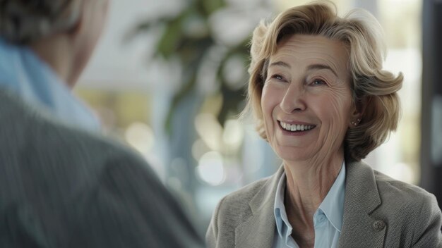 Een elegante oudere vrouw lacht hartelijk in een zacht gesprek