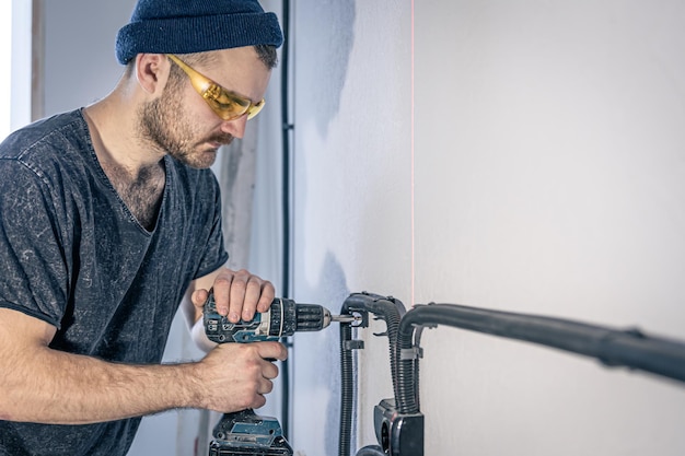 Foto een elektricien monteert binnen stopcontacten op de witte muur