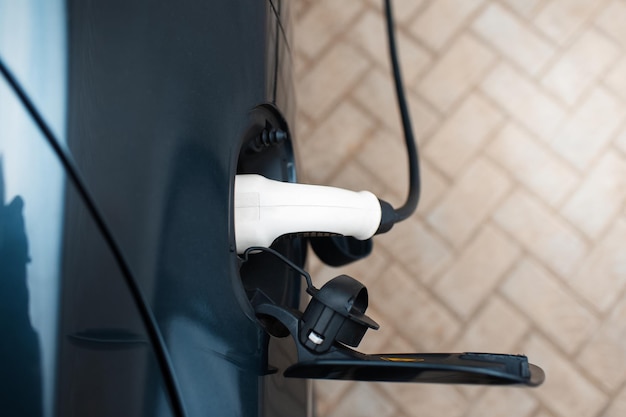 Een elektrische auto opladen bij het thuisstationBovenaanzicht van plug-in