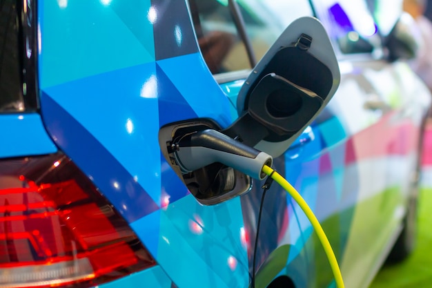 Een elektrische of hybride PHEV-auto opladen terwijl de voedingskabel is aangesloten. Oplaadstation voor elektrische auto's