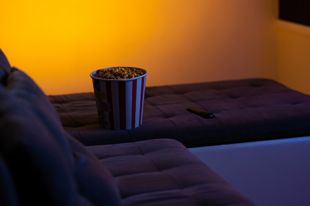 Een emmer popcorn op een zachte bank. Tijd om een interessante film te kijken.