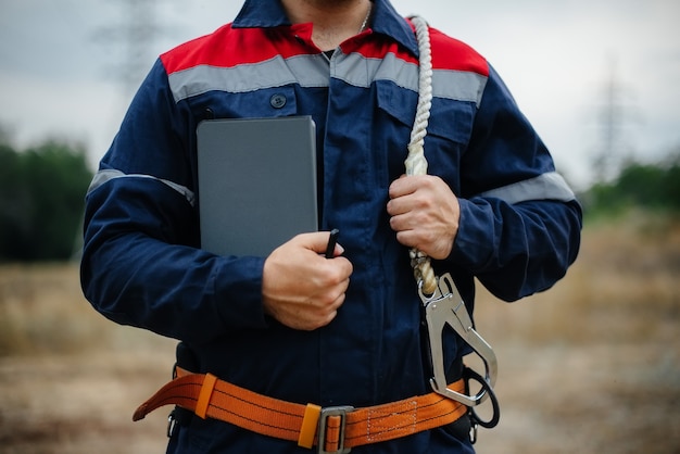 Een energiewerker inspecteert hoogspanningsleidingen