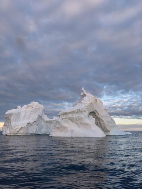 Foto een enorme gletsjer drijft in de zuidelijke oceaan voor de kust van antarctica bij zonsondergang.