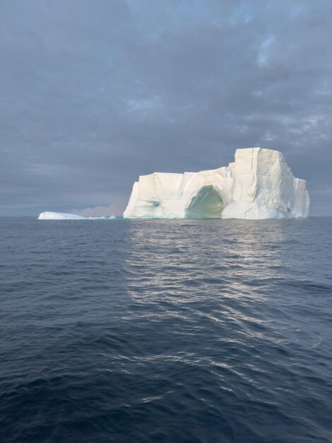 Foto een enorme gletsjer drijft in de zuidelijke oceaan voor de kust van antarctica bij zonsondergang.