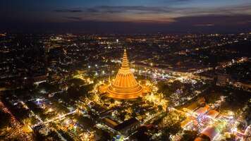 Een enorme gouden pagode gelegen in de zonsonderganggemeenschap van phra pathom chedi nakhon pathom thailand de meting werd openbaar gemaakt thailand luchtfoto van een wegrotonde met autokavels mooie