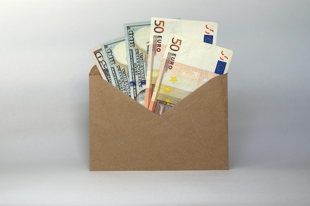 Een envelop met geld in verschillende coupures euro's en dollars