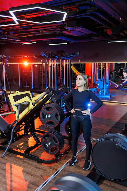 Een ervaren fitnesstrainer van een sportieve vrouw staat in de sportschool en denkt na over een trainingsplan. Dieet en gewichtsverlies concept. Personal trainers vrouwen in de sportschool