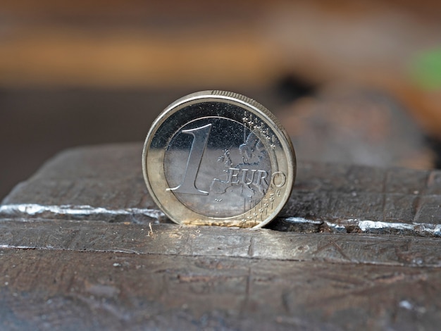 Een euromunt in een metalen greep. Concept van financiële problemen. Close-up, bovenaanzicht.