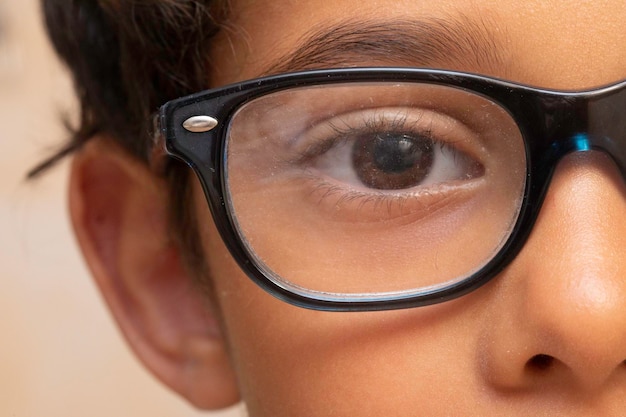 Een extreme close-up op het oog van een tienjarige jongen die een bril draagt. Zoet en onschuldig kind.