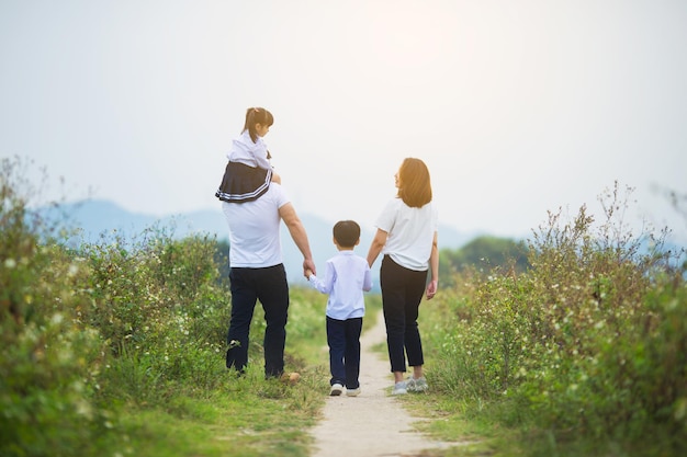 Een familie die hand in hand buiten loopt, Gelukkige familiale sfeer