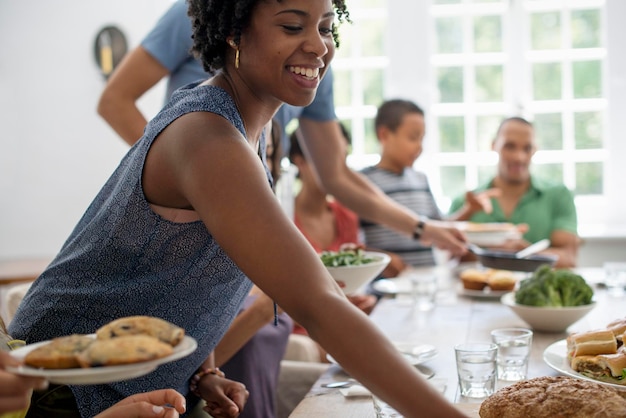 Een familie die mannen, vrouwen en kinderen verzamelt rond een eettafel en een maaltijd deelt