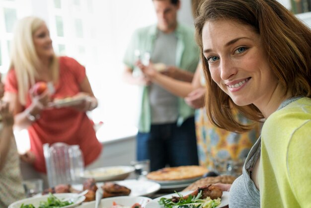 Een familiebijeenkomst voor een maaltijd Volwassenen en kinderen rond een tafel