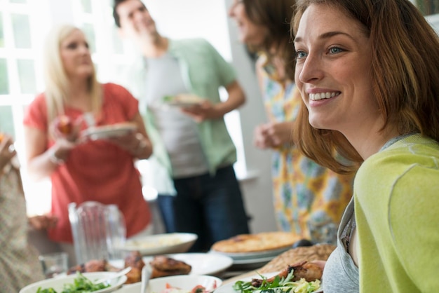 Een familiebijeenkomst voor een maaltijd Volwassenen en kinderen rond een tafel