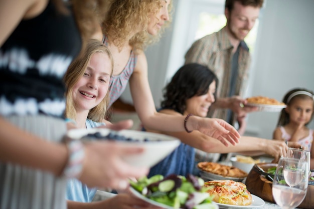 Foto een familiebijeenkomst voor een maaltijd volwassenen en kinderen rond een tafel