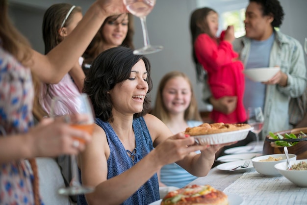 Een familiebijeenkomst voor een maaltijd volwassenen en kinderen rond een tafel