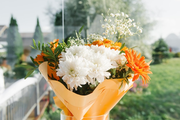 Een feestelijk boeket met witte chrysanten en oranje gerbera's voor een verjaardag of bruiloft