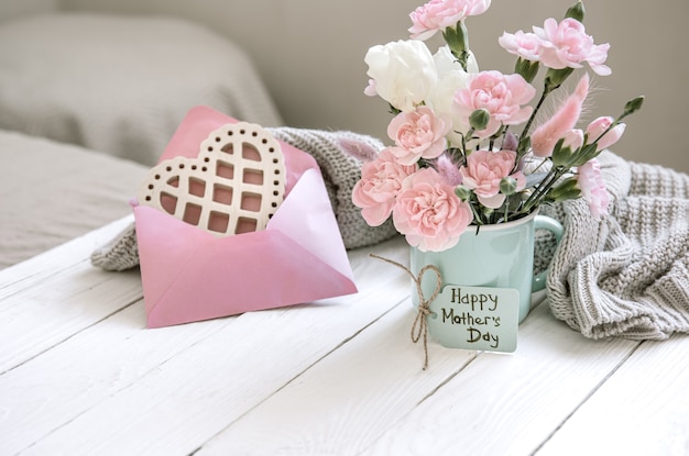Een feestelijke compositie met verse bloemen in een vaas, decoratieve elementen en een wens voor Vrolijk Pasen op een ansichtkaart.