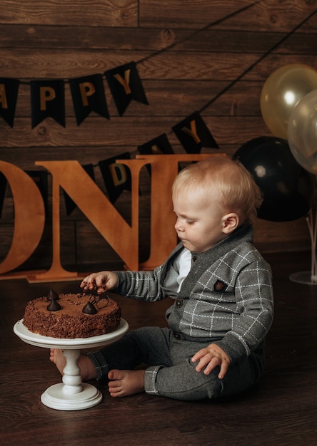 Een feestvarken in een grijs pak eet een chocoladetaart op een bruine achtergrond