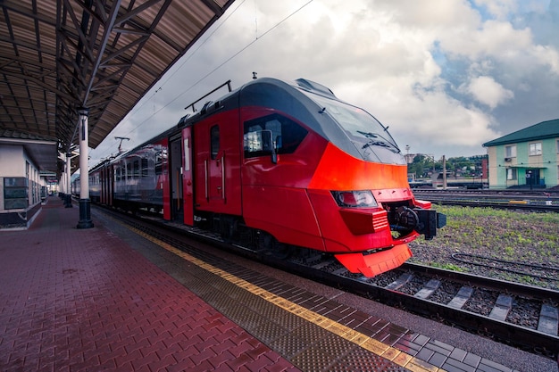 Een felrode trein staat op het perron van het treinstation in de stad Passagiersvervoer