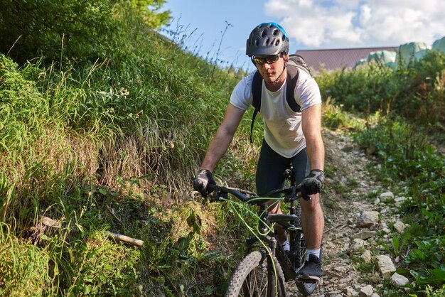 Een fietser fietst op extreme en gevaarlijke boswegen Selectieve focus