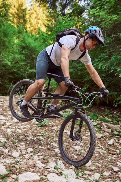 Een fietser fietst op extreme en gevaarlijke boswegen Selectieve focus