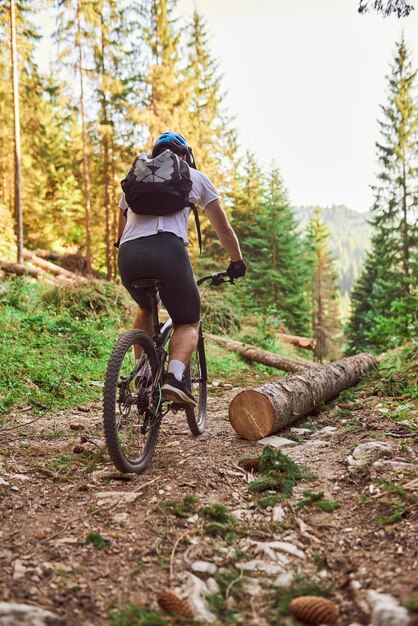 Een fietser fietst op extreme en gevaarlijke boswegen Selectieve focus