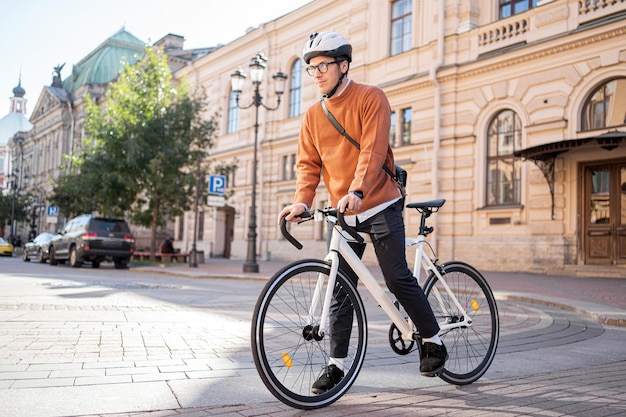 Een fietser met een helm rijdt op een fiets naar zijn werk in de stad ecotransport