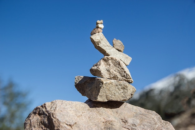 Een figuur van stenen tegen de achtergrond van een heldere hemel. Stenen piramide.