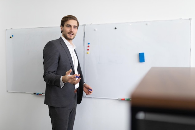 Een financiële analist van een man bespreekt de zaken van het bedrijf dat bij het bord staat