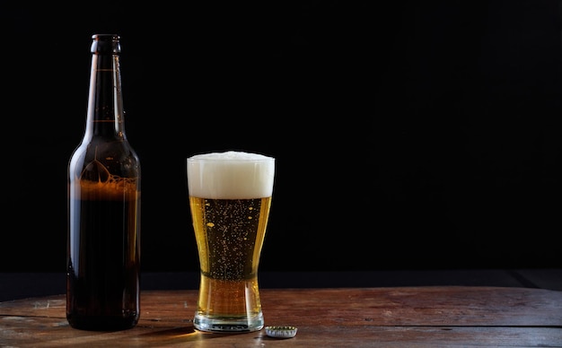 Een fles en een glas bier op een houten tafel donkere achtergrond