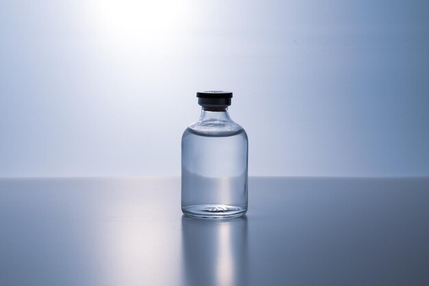 een fles heldere vloeistof met een zwarte dop erop