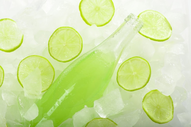 Een fles limonade met limoen op ijs