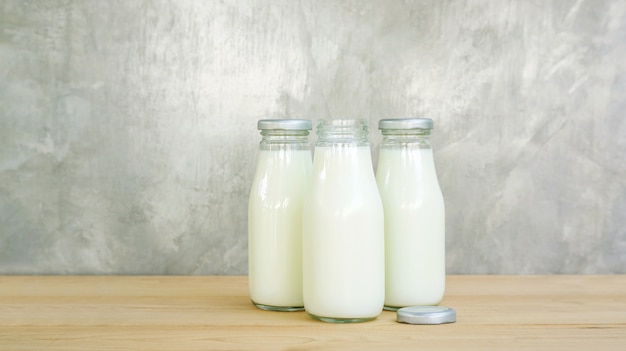 Een fles melk op een houten tafel.