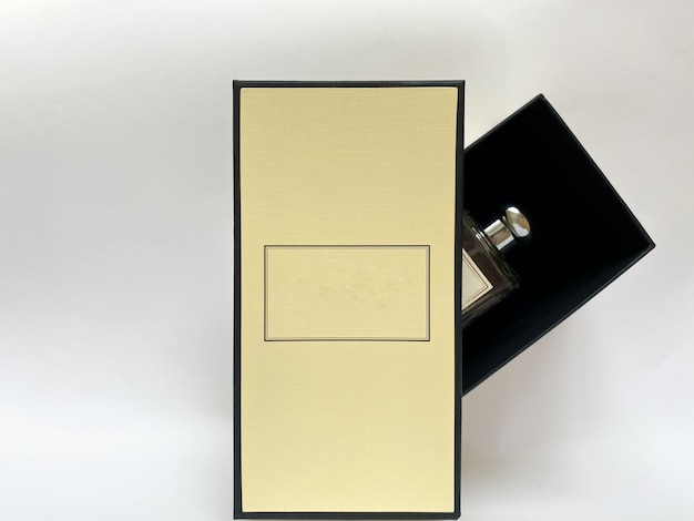 Een fles parfum uit een gele doos op een witte geïsoleerde achtergrond