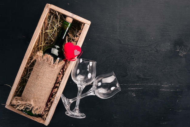 Een fles rode wijn en een boeket rode rozen. Valentijnsdag. Op een houten achtergrond. Bovenaanzicht. Vrije ruimte voor uw tekst.