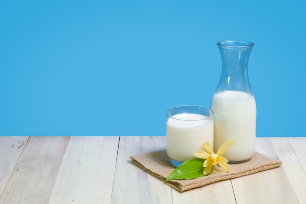 Een fles van rustieke melk en een glas melk op een houten tafel