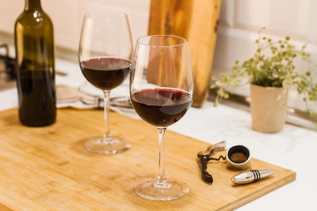 Een fles wijn en twee glazen op een houten plank op het aanrecht in de keuken
