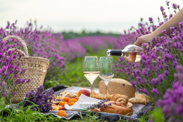 Een fles wijn op een achtergrond van een lavendelveld Glazen met wijnvruchten