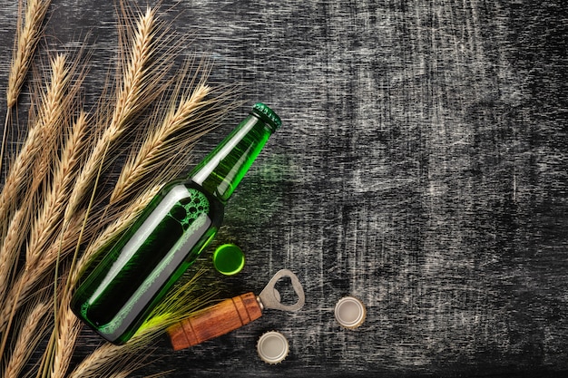 Een flesje bier met aartjes en opener op een zwarte gekrast schoolbord