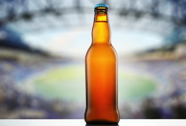 Een flesje bier op de achtergrond van een sportstadion