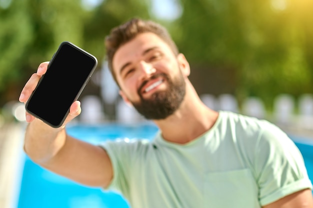 Een foto van een jonge knappe man met een smartphone