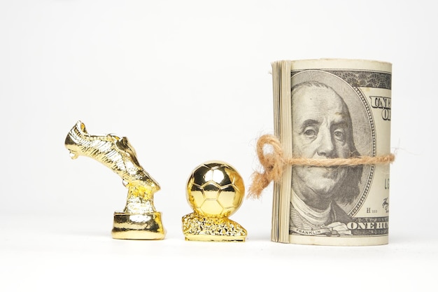 Foto een foto van miniatuur gouden bal en en laarzentrofee met nepgeld op witte achtergrond