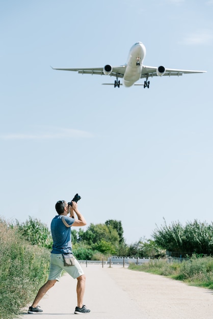 Foto een fotograaf die een foto van een opstijgend vliegtuig neemt