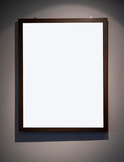 Een fotolijst met een donkere houten lijst aan de muur.