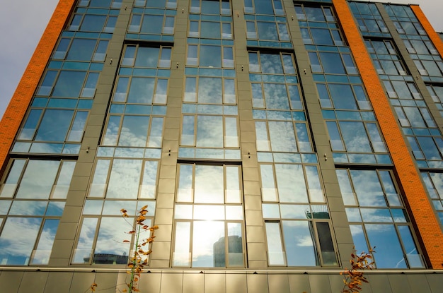 Een fragment van de muur van een huis met spiegelvensters.