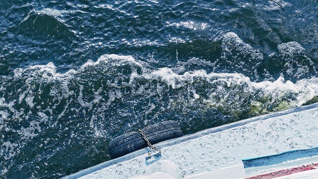 Een fragment van een boot en een wateroppervlak met golven bovenaanzicht